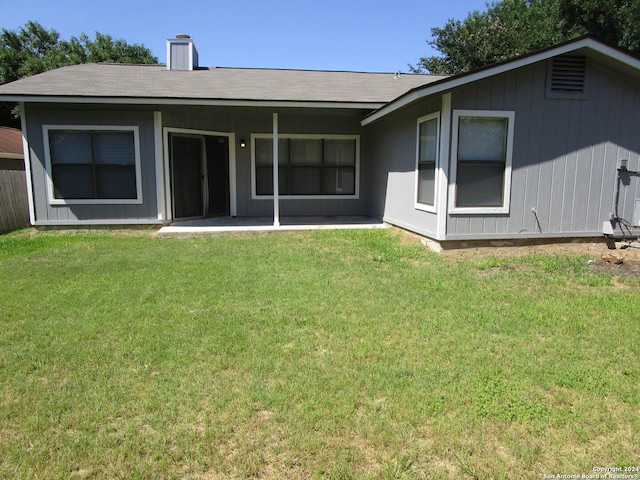 rear view of property featuring a patio and a lawn