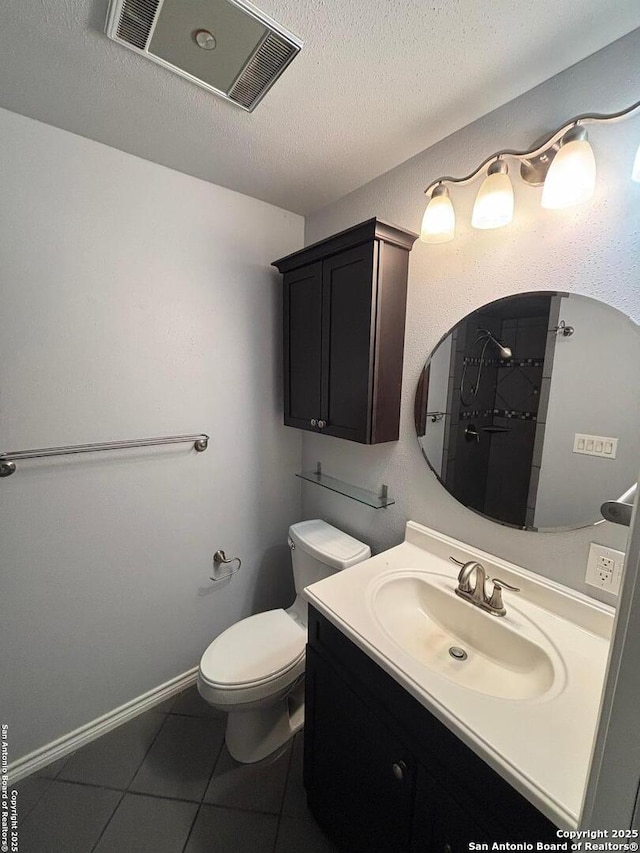 bathroom featuring tile patterned flooring, vanity, toilet, and a textured ceiling