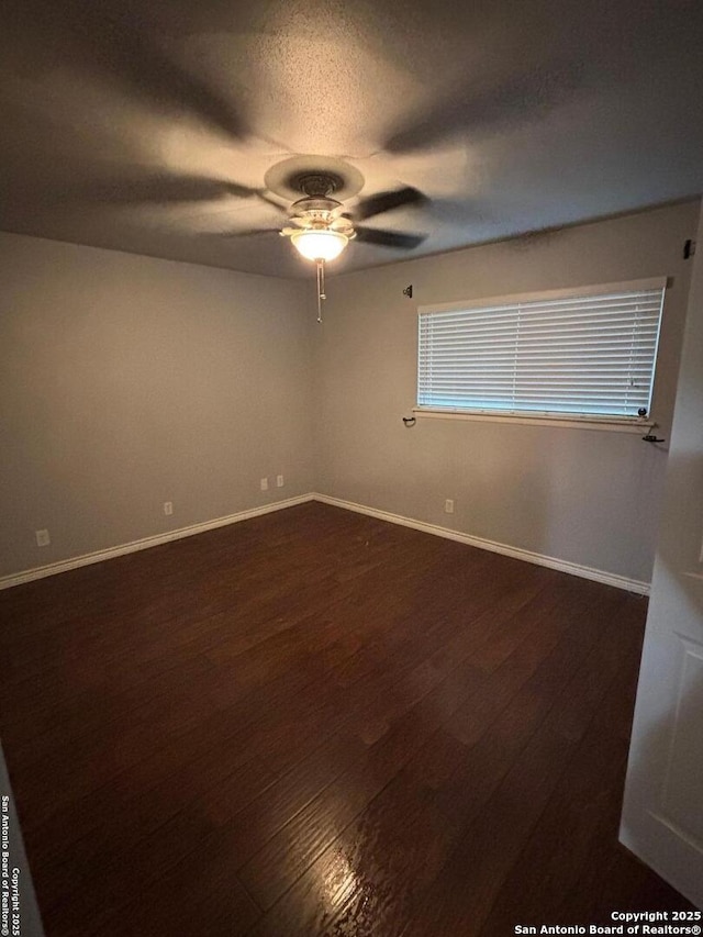 spare room with a textured ceiling, dark hardwood / wood-style floors, and ceiling fan