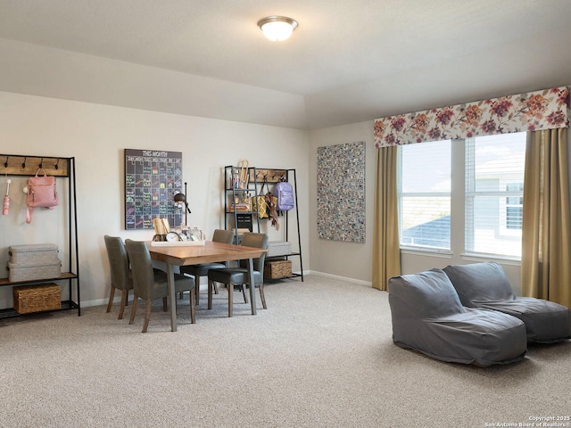 dining space featuring carpet flooring and vaulted ceiling