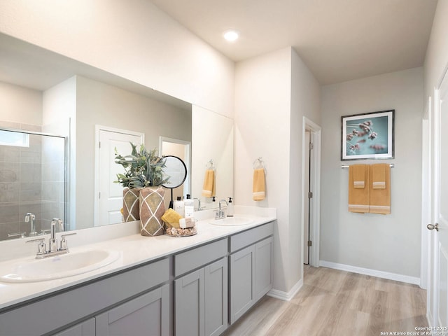 bathroom with wood-type flooring, an enclosed shower, and vanity