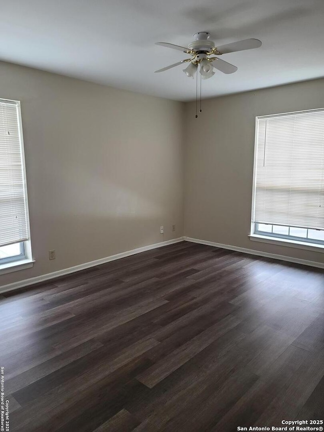 empty room with ceiling fan, a healthy amount of sunlight, and dark hardwood / wood-style floors