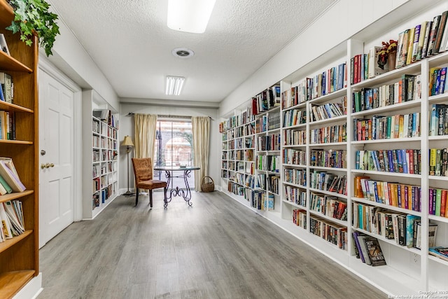 living area with hardwood / wood-style flooring and a textured ceiling