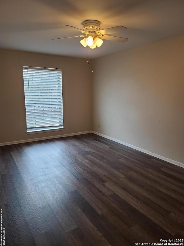 empty room featuring dark wood-type flooring and ceiling fan