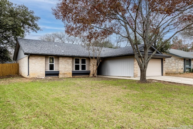 ranch-style house featuring a garage and a front lawn