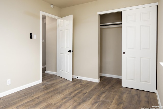 unfurnished bedroom featuring dark wood-type flooring and a closet