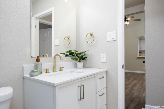 bathroom with vanity, wood-type flooring, ceiling fan, and toilet