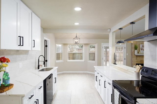 kitchen featuring black / electric stove, hanging light fixtures, wall chimney range hood, and sink