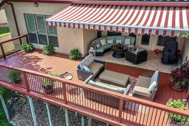 wooden deck featuring an outdoor living space with a fire pit