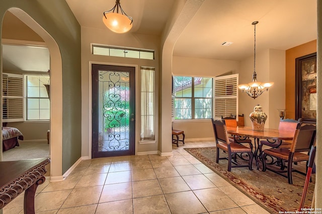 tiled entryway with an inviting chandelier