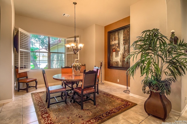 tiled dining area featuring an inviting chandelier