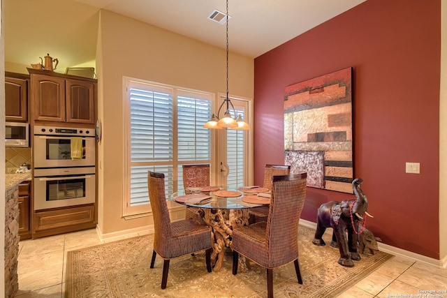 tiled dining area with an inviting chandelier