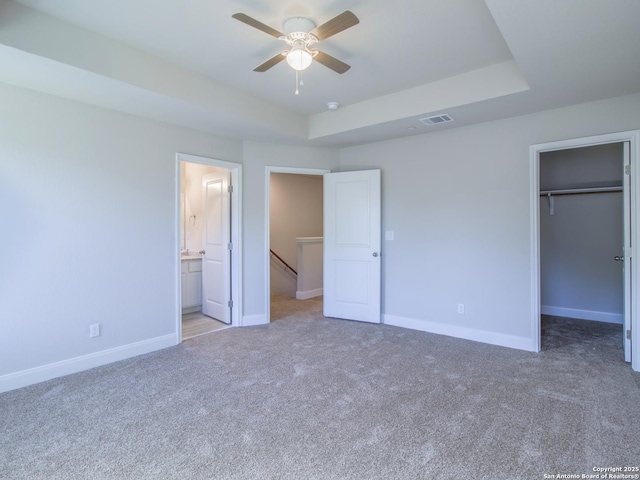 unfurnished bedroom featuring ensuite bathroom, a spacious closet, ceiling fan, and a closet