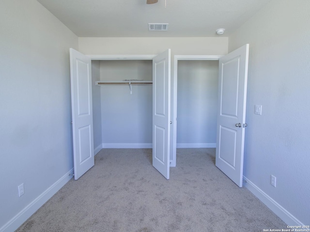 unfurnished bedroom with light colored carpet, a closet, and ceiling fan