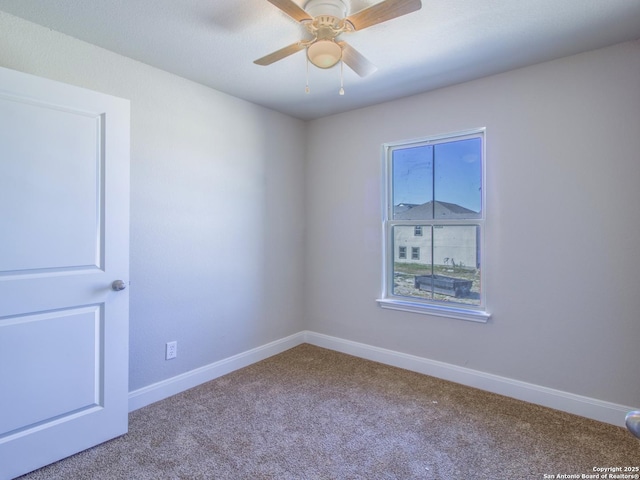 carpeted spare room with ceiling fan