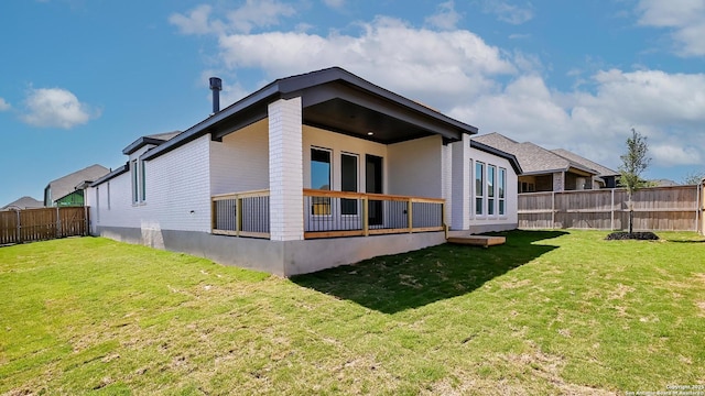 rear view of property featuring a fenced backyard, a wooden deck, and a yard