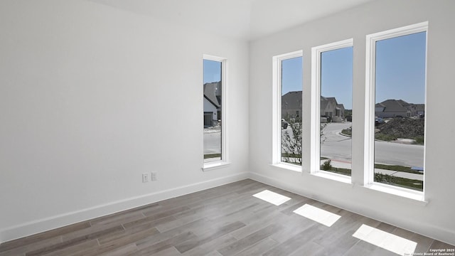 unfurnished room featuring baseboards and wood finished floors