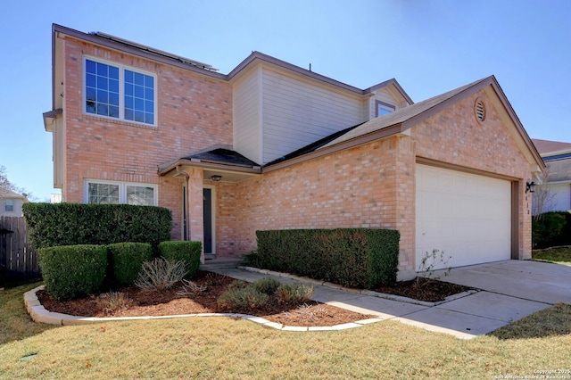 traditional-style house featuring an attached garage, a front lawn, concrete driveway, and brick siding