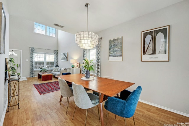 dining space featuring baseboards, visible vents, and light wood-style floors