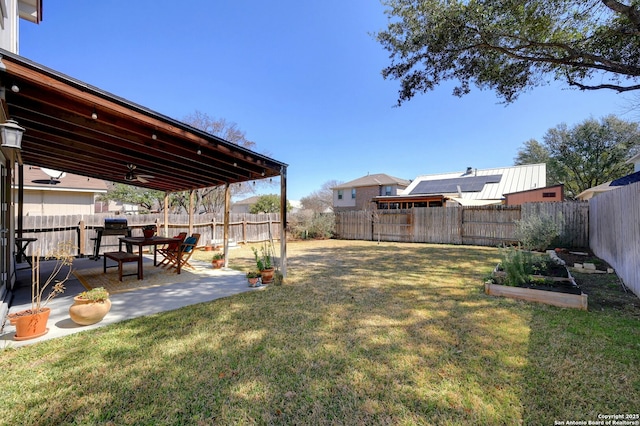 view of yard with a ceiling fan, a patio area, a vegetable garden, and a fenced backyard