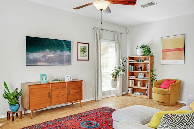 sitting room with ceiling fan, light wood-type flooring, visible vents, and baseboards