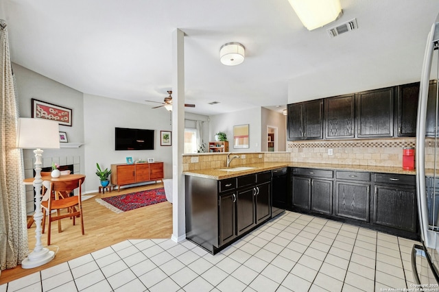 kitchen featuring a sink, light tile patterned floors, backsplash, and visible vents