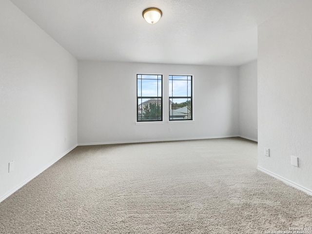 unfurnished room featuring light carpet