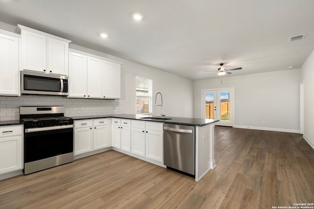 kitchen with appliances with stainless steel finishes, sink, and white cabinets