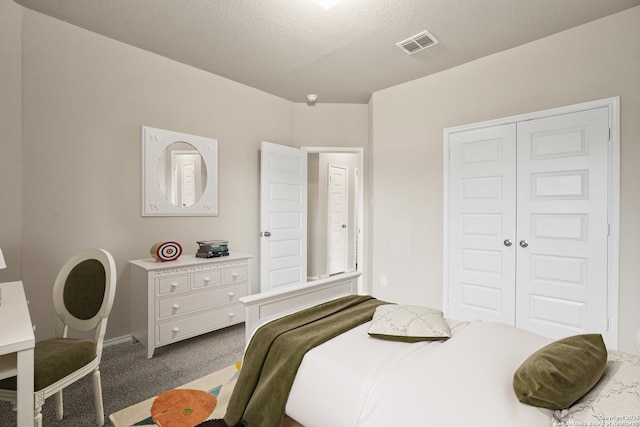 carpeted bedroom featuring a closet and a textured ceiling