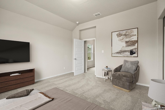 living area with light carpet, vaulted ceiling, and a textured ceiling