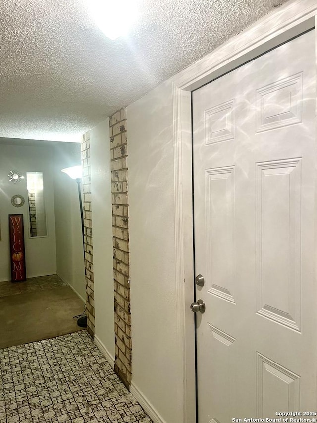 hallway with a textured ceiling