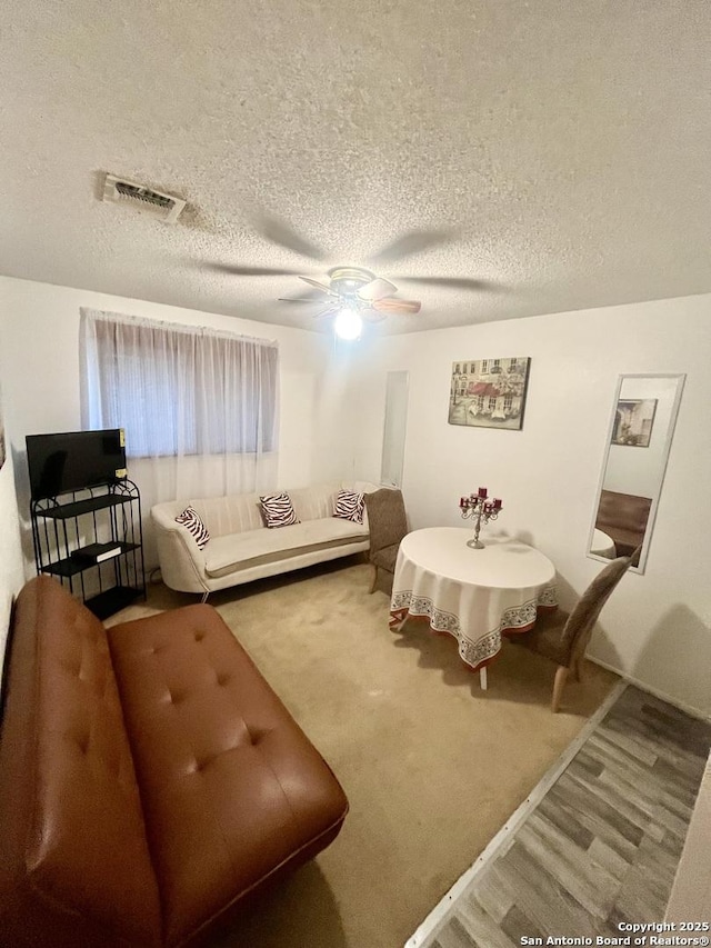 living room with ceiling fan, hardwood / wood-style floors, and a textured ceiling