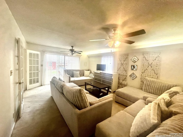 carpeted living room with ceiling fan and a textured ceiling