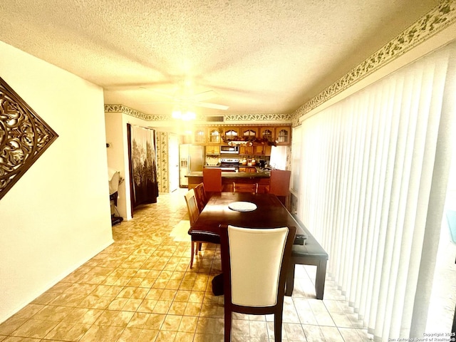 dining space featuring ceiling fan and a textured ceiling