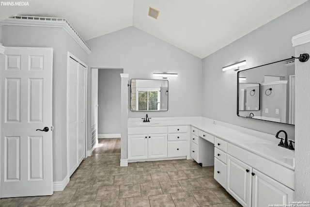 bathroom with lofted ceiling and vanity