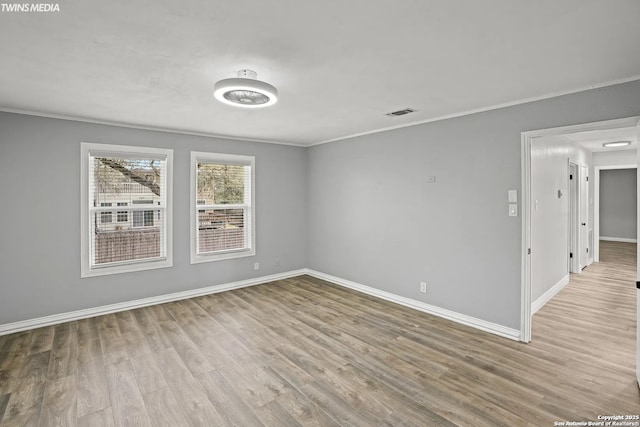 empty room featuring crown molding and light hardwood / wood-style flooring