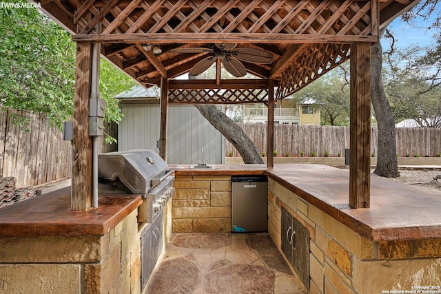 view of patio / terrace featuring exterior kitchen, a gazebo, a grill, and ceiling fan