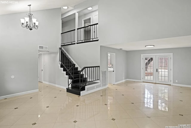 tiled entrance foyer with a notable chandelier and french doors