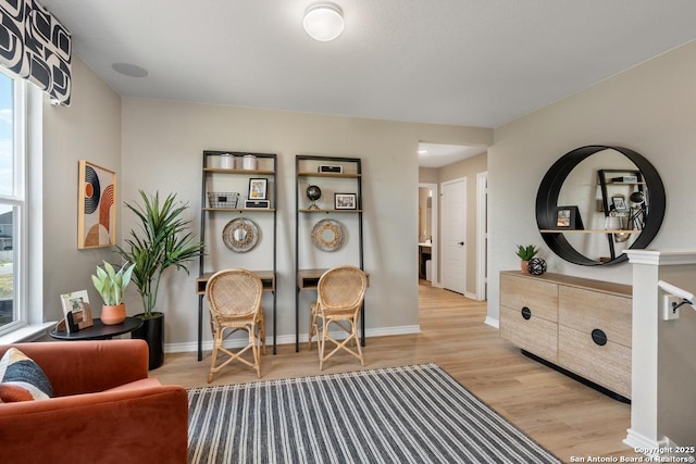 living area with plenty of natural light and light hardwood / wood-style floors