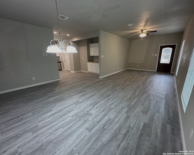 unfurnished living room with wood-type flooring and ceiling fan with notable chandelier