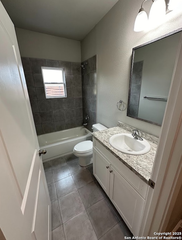 full bathroom featuring tiled shower / bath, vanity, and toilet