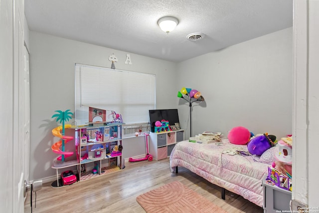 bedroom featuring a textured ceiling and light hardwood / wood-style floors