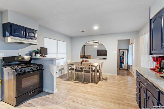 kitchen with gas stove, blue cabinetry, ceiling fan, and light hardwood / wood-style flooring