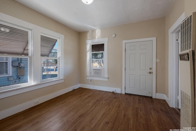 foyer with dark wood-type flooring, cooling unit, and a textured ceiling