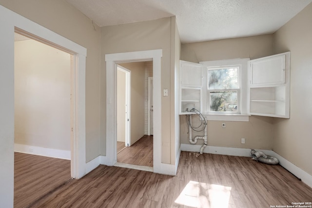 laundry room with washer hookup, wood-type flooring, and a textured ceiling