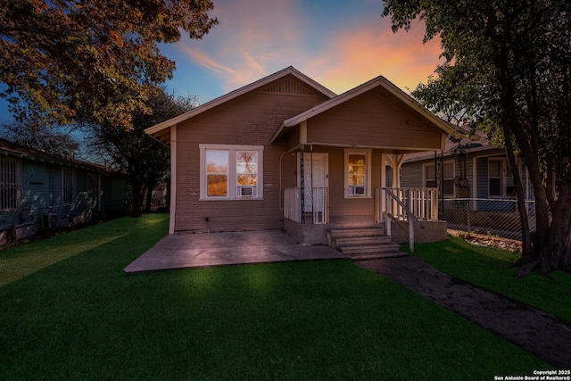 bungalow-style house featuring a lawn and a patio area