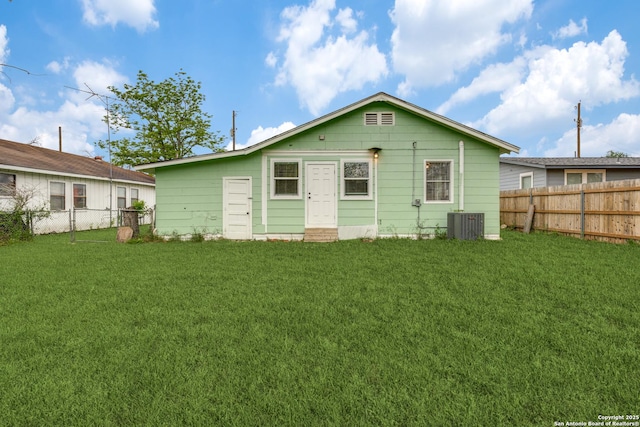 rear view of property with a lawn and central air condition unit