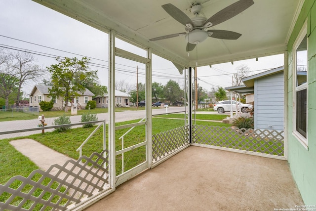 unfurnished sunroom with ceiling fan