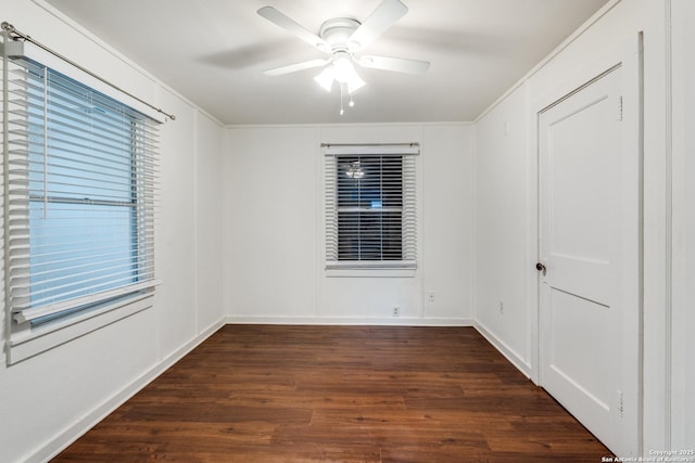 unfurnished room with crown molding, dark wood-type flooring, and ceiling fan