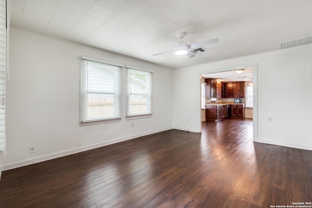 unfurnished living room featuring plenty of natural light, dark hardwood / wood-style floors, and ceiling fan